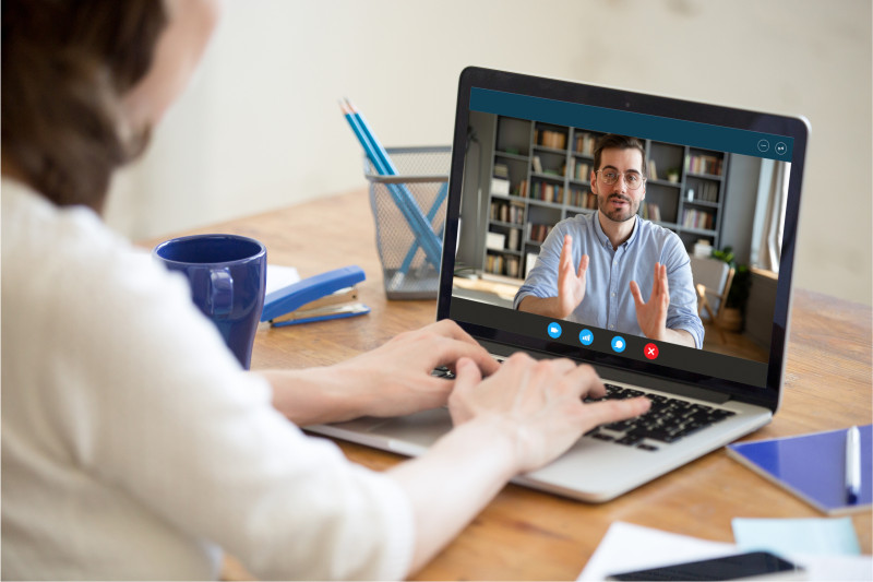 eatappie - Eine Person sitzt an einem Tisch und führt ein Online-Interview über den Laptop mit einem Mann, der gestikulierend auf dem Bildschirm zu sehen ist.